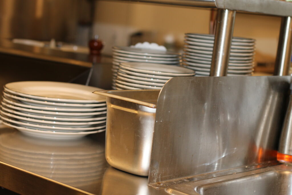 A stack of clean dishes in the dish pit waiting to be put away.